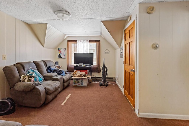 carpeted living area with a drop ceiling and baseboards