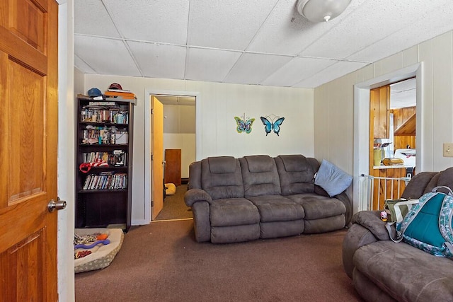 carpeted living area featuring a drop ceiling