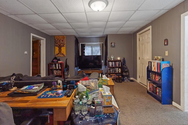 interior space featuring a paneled ceiling and baseboards