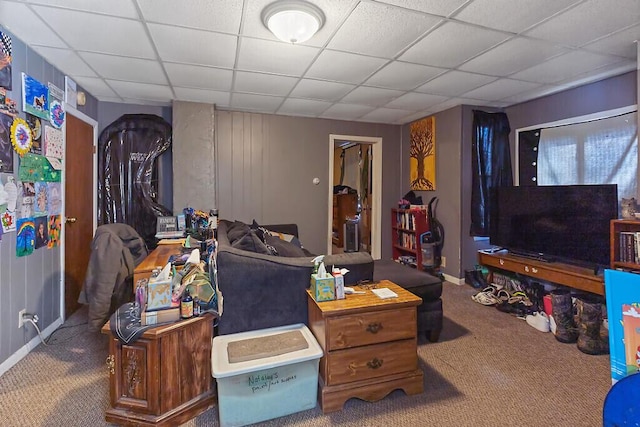 carpeted living area featuring a paneled ceiling and baseboards