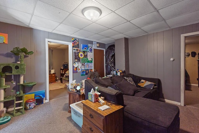 living area with a drop ceiling and carpet