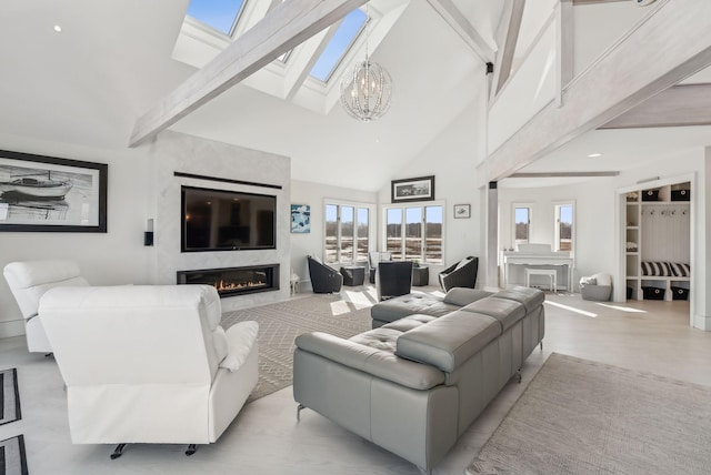 living area featuring a skylight, a chandelier, a premium fireplace, high vaulted ceiling, and beam ceiling