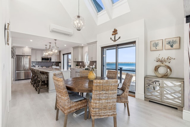 dining area featuring a healthy amount of sunlight, a wall mounted AC, and a notable chandelier