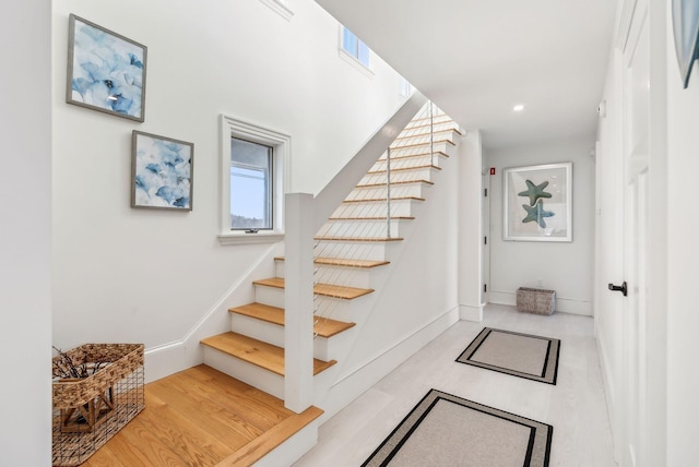 staircase with recessed lighting, baseboards, and wood finished floors