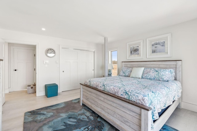 bedroom with baseboards, a closet, and wood finished floors