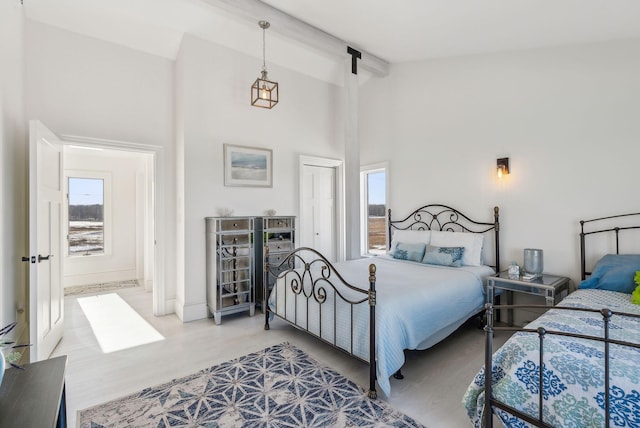 bedroom with high vaulted ceiling, beam ceiling, and a closet