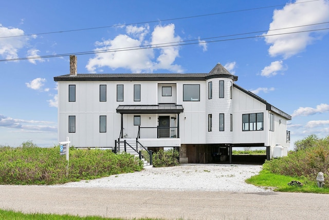 107 Marshall Point Rd, Kennebunkport, ME 04046 - view of front of property featuring a standing seam roof, a chimney, board and batten siding, a carport, and metal roof