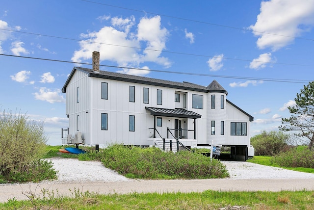 107 Marshall Point Rd, Kennebunkport, ME 04046 - view of front facade with a carport, board and batten siding, gravel driveway, a chimney, and a standing seam roof