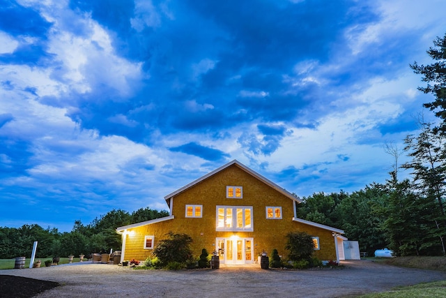 view of front of house with gravel driveway and french doors