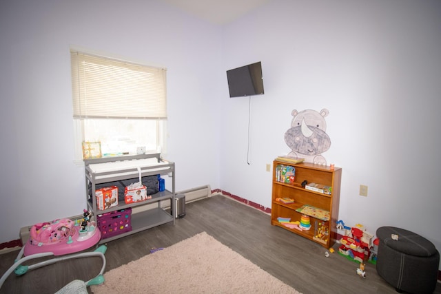 recreation room with a baseboard radiator and wood finished floors