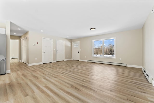 unfurnished living room featuring a baseboard heating unit, light wood-style flooring, baseboards, and baseboard heating