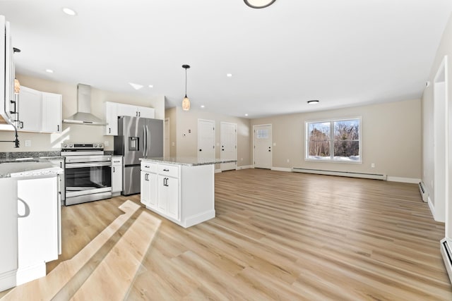 kitchen featuring a center island, appliances with stainless steel finishes, a baseboard heating unit, white cabinetry, and wall chimney exhaust hood