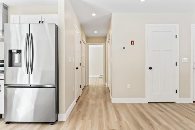 hall with baseboards, a baseboard heating unit, light wood finished floors, and recessed lighting