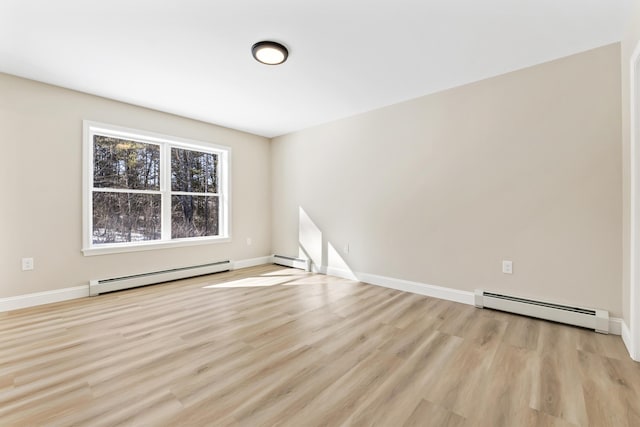 unfurnished room with a baseboard heating unit, light wood-style flooring, and baseboards