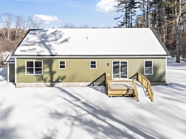 snow covered rear of property featuring a deck