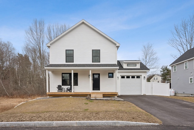 view of front of property featuring a shingled roof, an attached garage, covered porch, fence, and driveway