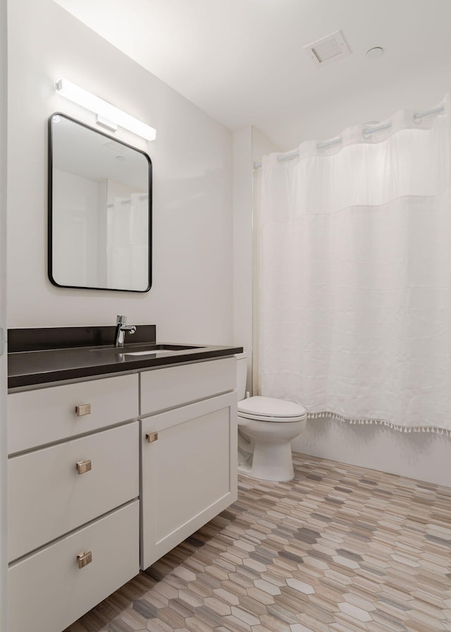 full bath featuring visible vents, vanity, and toilet