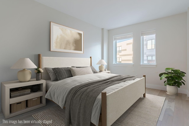 bedroom with light wood-style flooring and baseboards