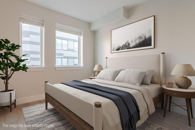 bedroom with baseboards and wood finished floors