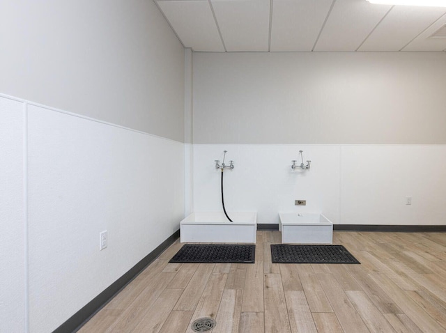 clothes washing area with baseboards, laundry area, hookup for a washing machine, and light wood-style floors