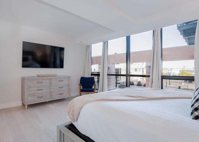 bedroom with floor to ceiling windows, baseboards, and wood finished floors