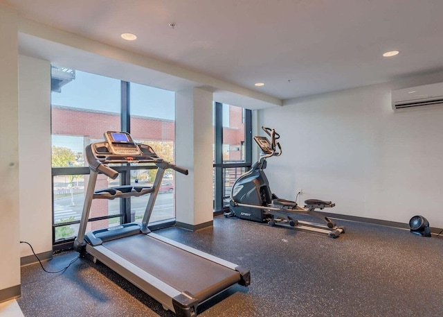 workout area with recessed lighting, a wall unit AC, and baseboards