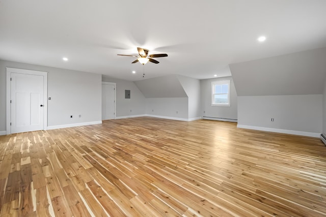 additional living space with light wood-style flooring, a ceiling fan, a baseboard heating unit, and baseboards