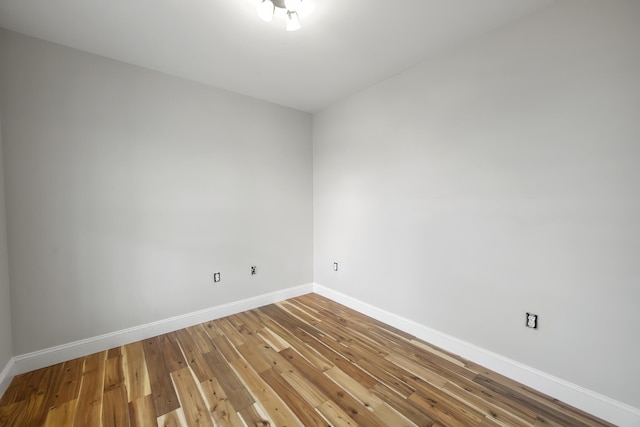 spare room featuring baseboards and hardwood / wood-style floors