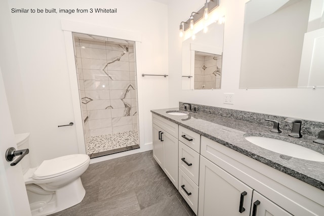 full bath with tiled shower, a sink, toilet, and double vanity