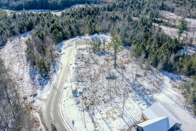 drone / aerial view with a wooded view