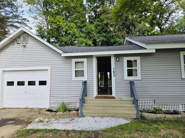 view of front of home featuring a garage, entry steps, and roof with shingles