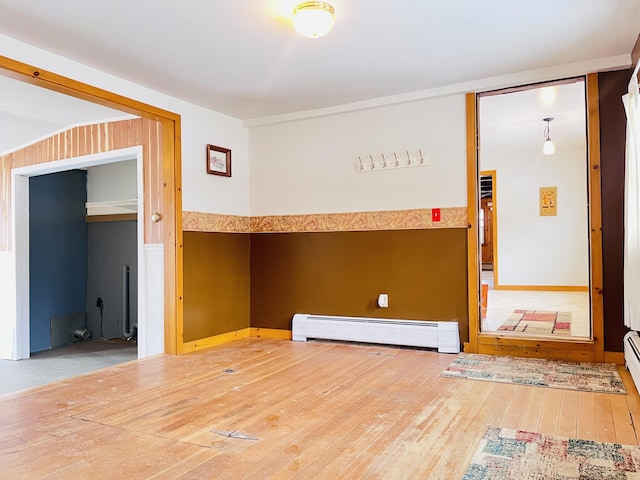 interior space with a baseboard heating unit and hardwood / wood-style floors