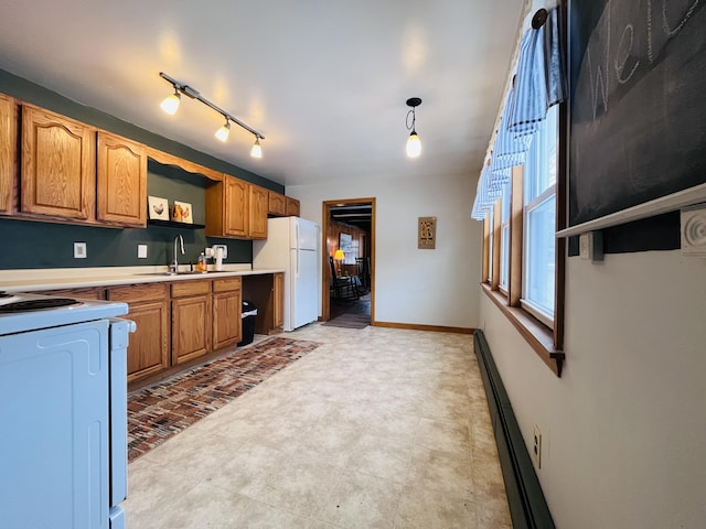 kitchen featuring white appliances, a sink, baseboards, light countertops, and brown cabinets