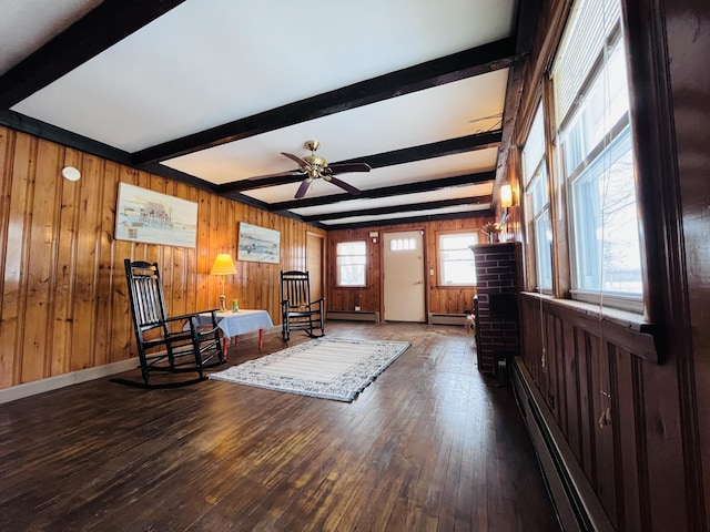 interior space featuring hardwood / wood-style floors, baseboard heating, a ceiling fan, beamed ceiling, and baseboards