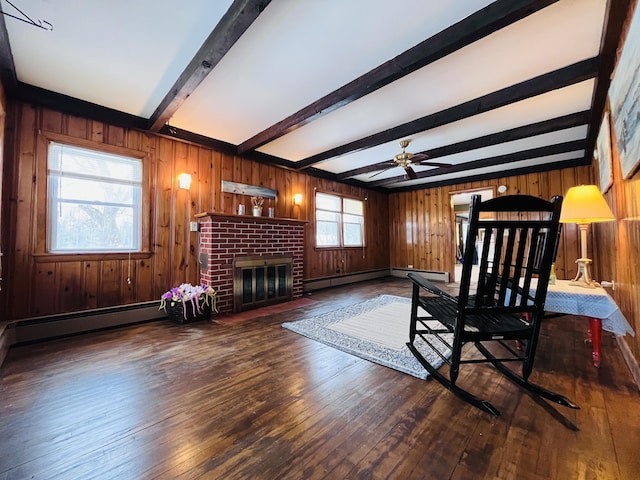 sitting room with a fireplace, a baseboard heating unit, wooden walls, beamed ceiling, and hardwood / wood-style flooring