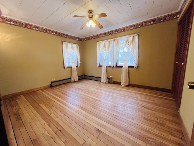 spare room with light wood-style floors, ceiling fan, and baseboards