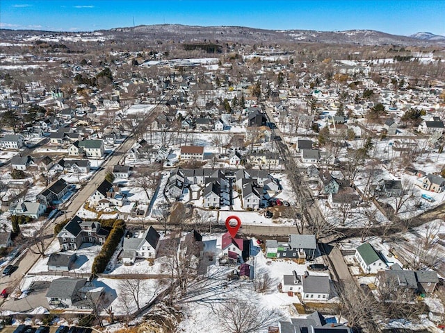 snowy aerial view featuring a mountain view and a residential view