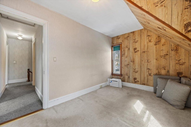 bonus room featuring carpet floors, a wall mounted air conditioner, and baseboards