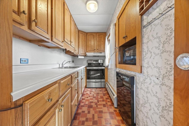 kitchen with brown cabinets, under cabinet range hood, light countertops, black appliances, and a sink