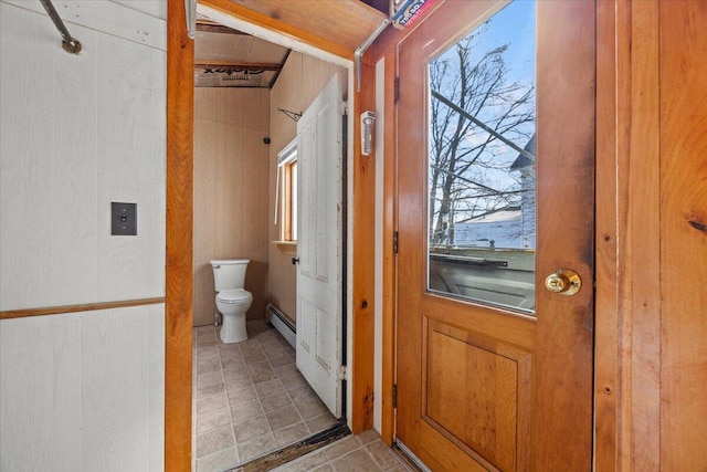 bathroom with toilet, plenty of natural light, a baseboard radiator, and tile patterned flooring