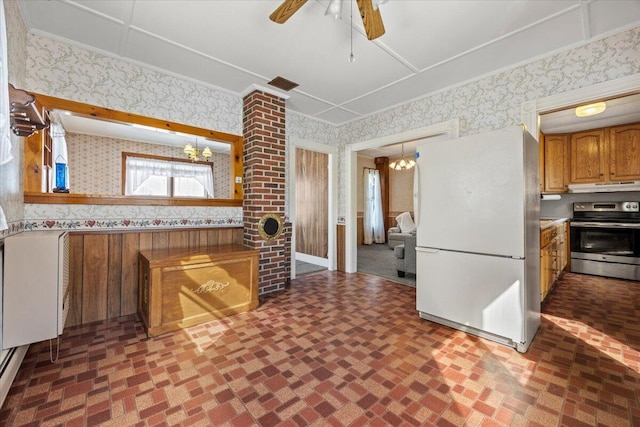 kitchen featuring wallpapered walls, electric range, brown cabinetry, freestanding refrigerator, and under cabinet range hood