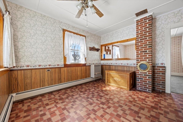 interior space featuring wallpapered walls, crown molding, a baseboard heating unit, and a wainscoted wall