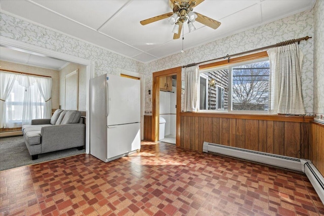 interior space featuring a baseboard heating unit, crown molding, ceiling fan, and wallpapered walls