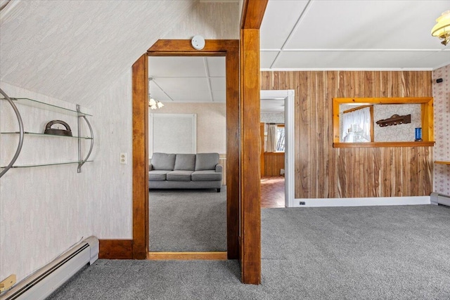 interior space featuring carpet, wood walls, and baseboard heating