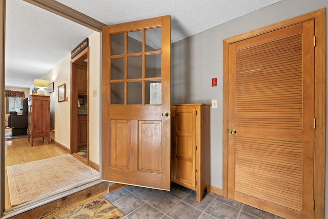 interior space with a textured ceiling and baseboards