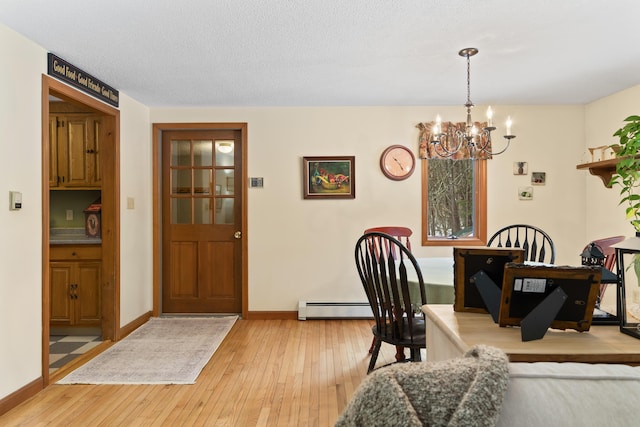 dining room with an inviting chandelier, a baseboard heating unit, light wood-style floors, a textured ceiling, and baseboards