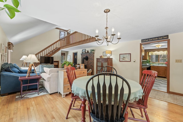 dining space featuring light wood-style floors, stairway, and a chandelier