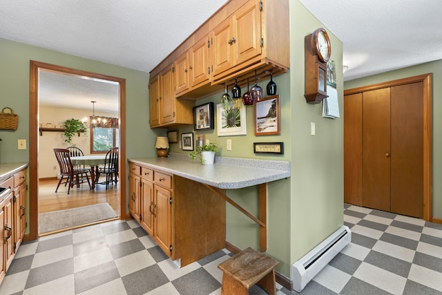 kitchen featuring light floors, a baseboard radiator, light countertops, and a notable chandelier