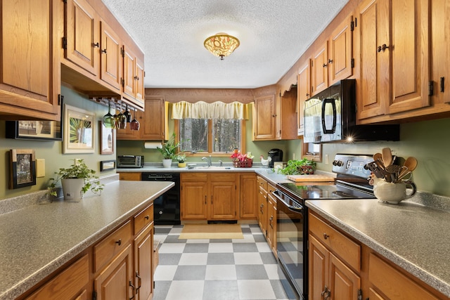 kitchen featuring light floors, brown cabinets, a sink, and black appliances