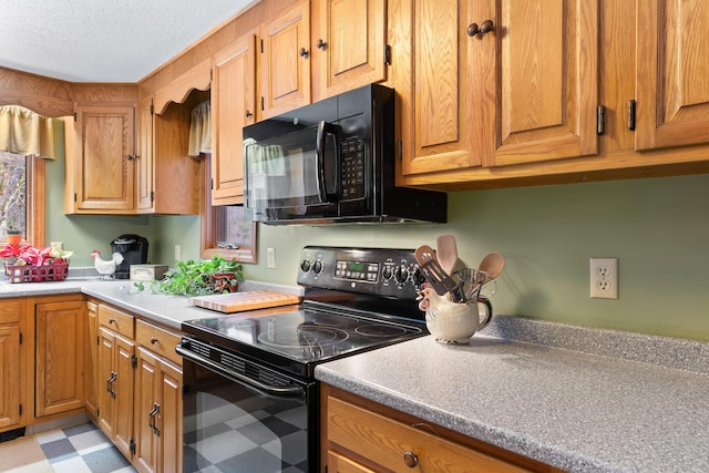 kitchen with light floors, brown cabinetry, and black appliances